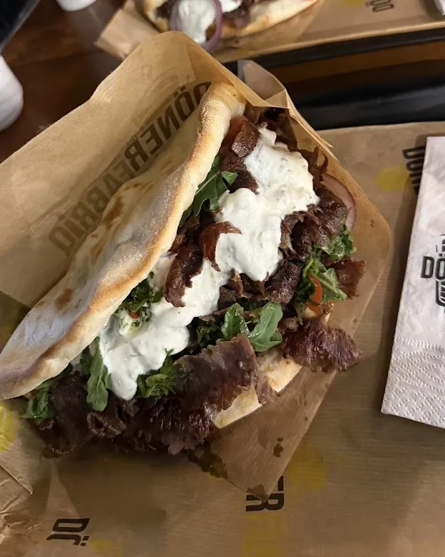 Zwei Fabriq Döner mit weißer Soße im Markenpapier